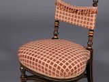 an antique chair with a checkered upholstered seat and wooden legs