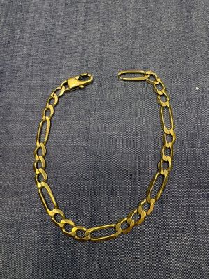 un bracelet à chaîne en or avec un fermoir, sur fond gris
