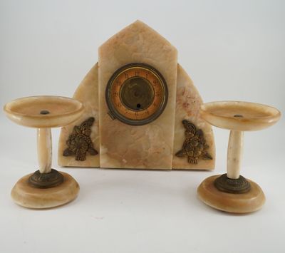 two candles and a clock sitting on a table