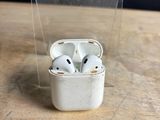 two airpods sitting in a clear container on a table