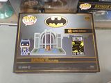 the box is open on a table with a batman figurine in it