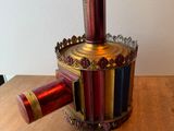 un vase rouge et doré posé sur une table en bois