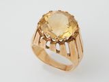 a gold ring with a large citrine stone in the center