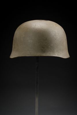 un gros plan d'un casque posé sur un support, sur fond noir