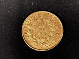 a close up of a gold coin on a black surface