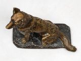 a bronze statue of a wolf on top of a rock