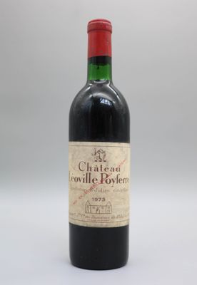 une vieille bouteille de vin posée sur une table blanche