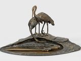sculpture en bronze représentant deux oiseaux posés sur un rocher, sur fond blanc