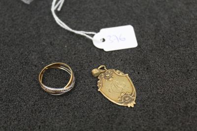 two gold rings and a silver ring on a black surface
