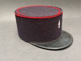 une image représentant un chapeau noir orné d'un ruban rouge sur le dessus