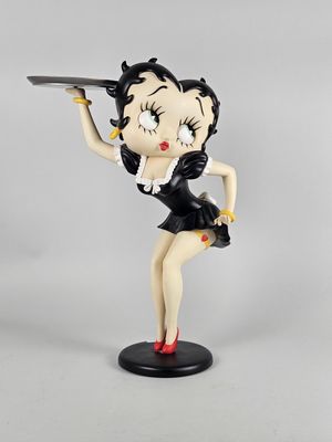 La figurine tient un plateau et un couteau à la main.