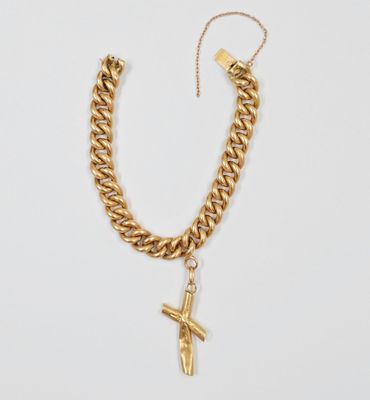 un collier à chaîne en or auquel est suspendu un pendentif en forme de croix