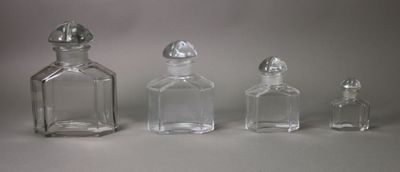 three small glass bottles sitting next to each other on top of a table