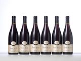 six bottles of wine lined up in a row on a table