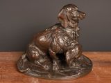 bronze statue of a dog and a cat on a wooden table