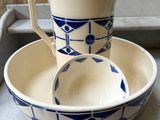 two bowls and a pitcher sitting on a counter