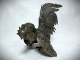 a silver statue of a rooster on a white surface