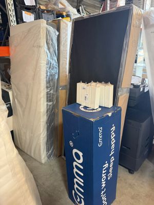 boxes of mattresses and other furniture are stacked in a warehouse