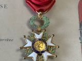 un ruban rouge et une médaille d'or sur une feuille de papier