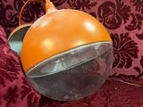an orange object sitting on top of a red couch