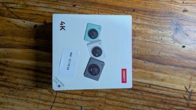 a box with two cameras on it on a wooden table