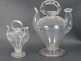 two glass vases sitting next to each other on a table