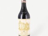 a bottle of red wine sitting on top of a white table