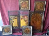 five framed pictures on the floor next to a red curtain