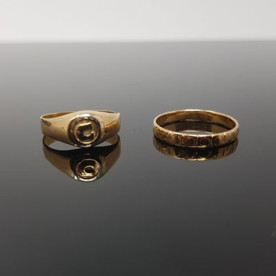 deux bagues en or sur une surface noire avec un fond blanc