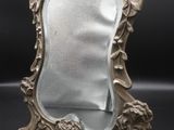 an image of a silver mirror sitting on top of a table