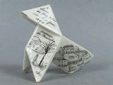 an origami of a paper airplane with a picture of a town on it