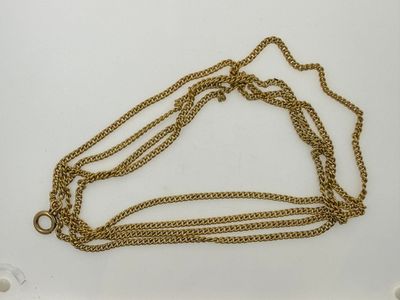a close up of a gold chain on a white surface