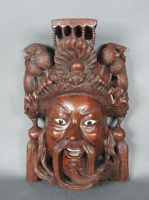 une image représentant un masque en bois sculpté orné d'oiseaux