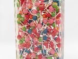brightly colored lollipops in a clear box on a white background