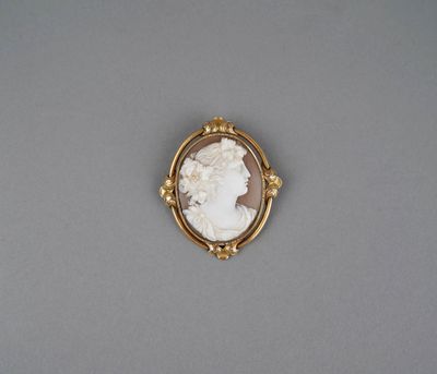 un camée blanc et doré représentant une femme de profil