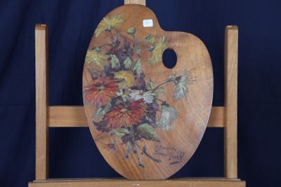 un chevalet en bois sur lequel est peinte une composition florale