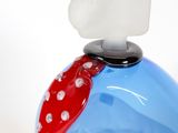 a blue vase with a red polka dot decoration on it