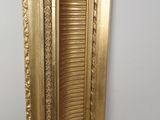 an image of a gold framed mirror hanging on a wall
