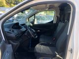 the interior of a white van with black seats and a steering wheel