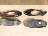 four pairs of shoes are lined up on a wooden surface