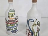 two bottles with octopus designs on them on a white surface