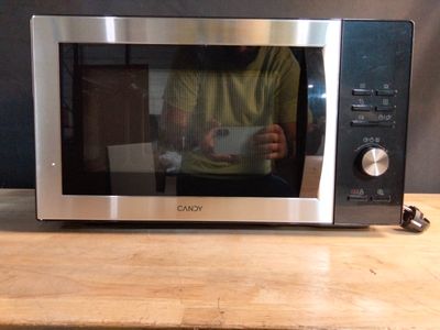 un homme en train de se prendre en photo dans un micro-ondes