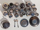 a lot of silver dishes and spoons on the table
