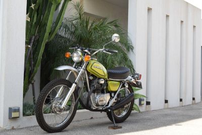 a green motorcycle parked on the side of the road