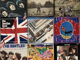 some of the beatles albums are on display on a table