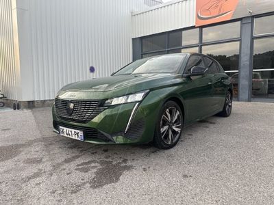 the green car is parked in front of a building