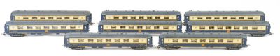 six blue and white train cars sitting next to each other on a white surface