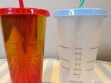 two cups with straws in them sitting on a table