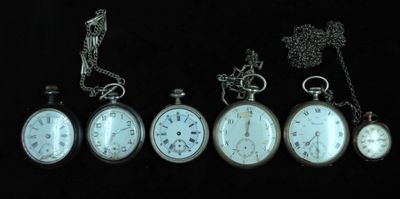 five different types of pocket watches on a black background