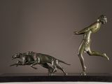 bronze statue of a woman running with a dog on a leash